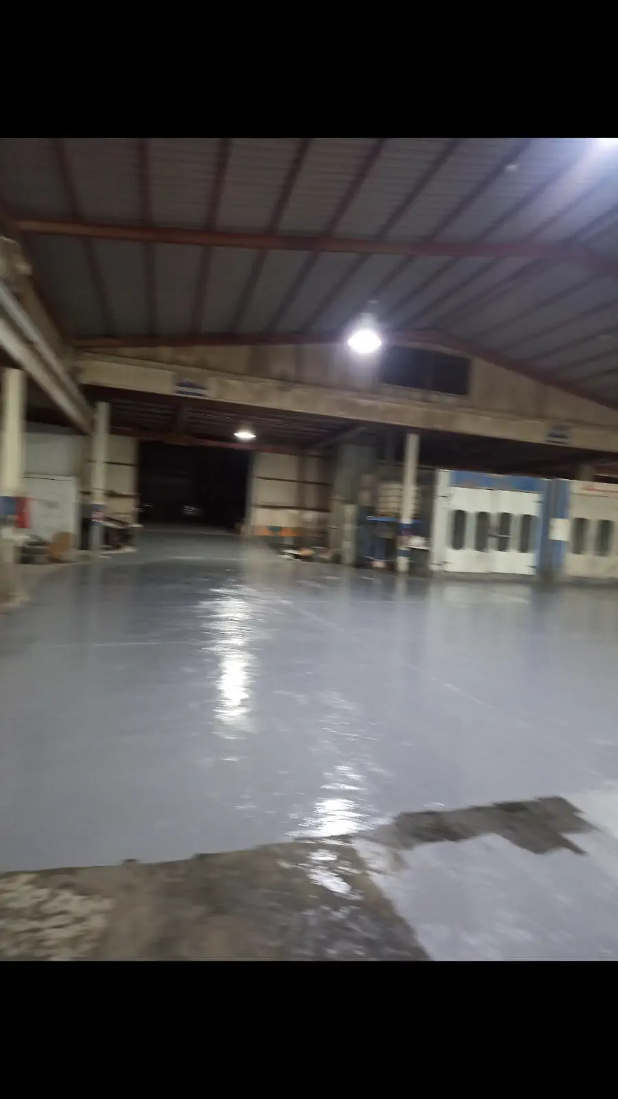 دهان أرضيات إيبوكسي رمادي داخل مستودع أو مساحة صناعية
